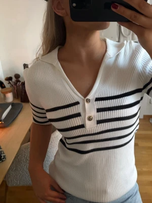 Vit ribbad randig topp med krage MassimoDutti  - Vit svart ribbad stickad topp från Massimo dutti med krage och fina detaljer i storlek S, aldrig använd 🩷