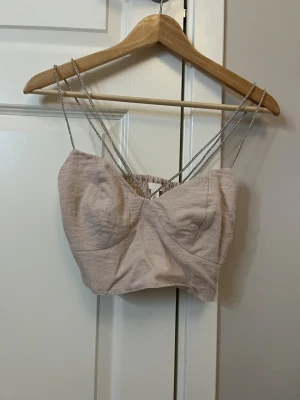 Beige magtröja - Snygg beige magtröja med tunna, dubbla axelband i silverfärg.