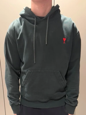 Mörkgrön Ami Paris hoodie - Riktigt lyxig hoodie från Ami paris. Använd otroligt lite. Riktigt fet märkgrön färg och storleken är S. Mitt pris är 890 med tanke på det dyra nypriset. 