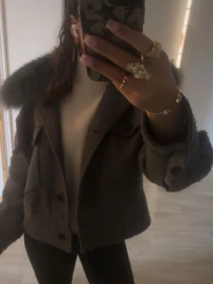 Meotine kappa -  PRIS ÄR DISKUTERBART, Meotine jacka, grå/grön i färgen ( rätt nopprig ) där av priset, ena fästet till pälsen har även gått upp men annars superfin