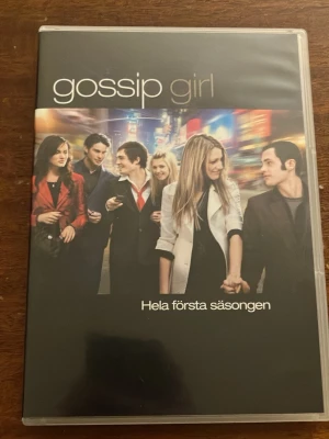 Gossip Girl Säsong 1 DVD-box - Säljer hela första säsongen av Gossip Girl på DVD. Boxen innehåller flera skivor med alla avsnitt från säsong 1. Omslaget har en bild på huvudkaraktärerna mot en stadsmiljö. Perfekt för dig som gillar drama och intriger i New York-miljö.  Skivorna är mycket fina men ej funktionstestad