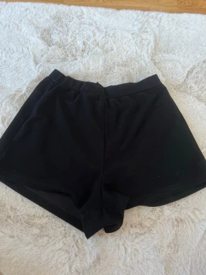 Svarta  shorts - Ett par svarta, enkla shorts med elastisk midja. Tunnt tyg och passar perfekt för varma dagar eller som chillplagg hemma.