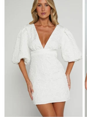 Populär vit kort klänning med puffärmar från showpo - Säljer denna jättefina populära studentklänningen från showpo! Köpt begagnad men endast testad av mig då jag tyckte den var för stor. I nyskick då den endast var använd en gång av personen innan. Förra ägaren har även sytt igen vringningen, men det ska inte vara några problem alls att sprätta upp, har bara inte gjort det då den ändå inte passade mig!🥰🥰