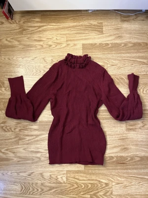 Vinröd ribbad polotröja Bubbleroom XS - Supersnygg vinröd ribbad polotröja från Bubbleroom i storlek XS. Tröjan har volangkant vid halsen och långa ärmar med bred mudd. Perfekt till höst och vinter för en trendig look. Aldrig använd. 