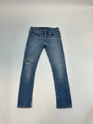 Dondup George  - Ett par klassiska blå jeans med rak passform och lätt slitning på vänster lår. Jeansen har fem fickor och normal midja. Perfekta för en avslappnad och trendig look.