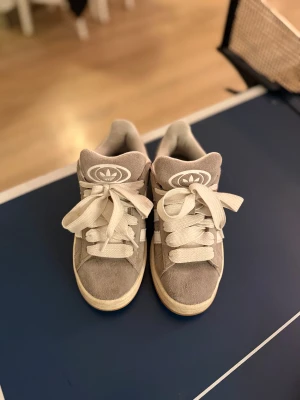 Adidas Campus 00s grå sneakers strl 36⅔ - Säljer ett par gråa adidas campus skor i storlek 36⅔! Passar för både killar och tjejer, har tyvärr inte original lådan kvar. Jag har använt dessa ett par gånger men fick därefter ett par andra skor så därför kom inte dessa så mycket till användning för mig.