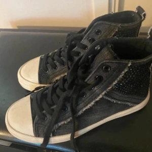 Zara skor - Snygga svarta sneakers i jeansmaterial med glittriga detaljer på sidorna. De har en klassisk snörning och en vit sula som ger en cool kontrast. Perfekta för både vardag och festliga tillfällen!