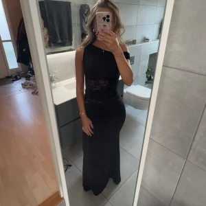Svart långklänning med spetsdetalj - Trendig svart klänning som aldrig är använd så helt ny! Säljer då jag inte hann skicka tillbaka innan retur tiden gick ut🙃 pris går att förhandla vid en snabb affär😇💕