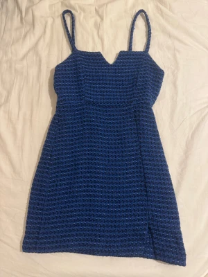 Blå kort klänning från Zara - Blå kort klänning från Zara med vävt strukturmönster och smala axelband. Klänningen har en snygg slits framtill och markerad midja för en slim passform. Dragkedja i ryggen. Använt 2 gånger så mycket nytt skick. Bilden är på mig när jag har på mig klänningen 