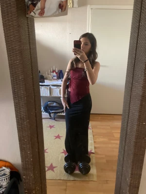 Svart långkjol med slimmad passform - Säljer en svart långkjol med slimmad passform. Kjolen har en enkel och stilren design som sitter snyggt längs kroppen och ger en clean siluett. Perfekt att matcha med crop tops eller stickade tröjor för en trendig look. Om fler bilder önskas är det bara att skriva 🩷