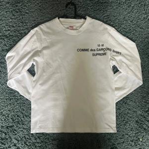 Supreme x Comme des Garçons - Vit långarmad tröja med CDG x Supreme collab. Kan skicka mer bilder om önskas. Autentikationen är oklar.