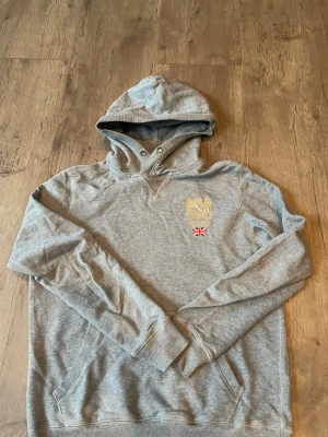 Grå hoodie från Morris  - Snygg grå hoodie från Morris i storlek S. Skön tröja som jag har använt rätt så mycket. har också tappat bort snörena.Köpte den ny för 1200kr och mitt pris är 360 kr. Kom gärna med pris förslag!