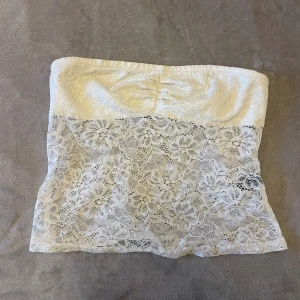vit tubtopp - vit tubtopp med snyggt blommigt spetsmönster, använd fåtal gånger men är i bra skick.