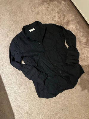 Linneskjorta - Säljer en schysst mörkblå linneskjorta från uniqlo. Den är i storlek xs.