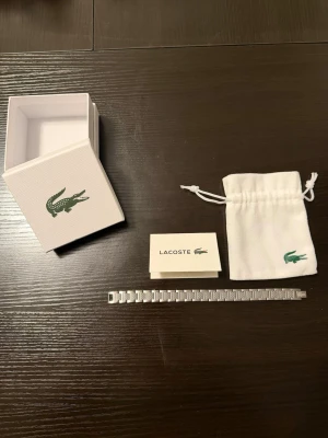 Silverfärgat armband från Lacoste - Ifall den är för stor så kan du minska korta den ner så att den blir mindre 
