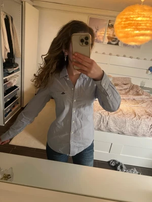 Blårandig skjorta från Hampton Republic - Snygg blårandig skjorta från Hampton Republic med klassisk krage och knappar framtill. Skjortan har långa ärmar och diskreta vita och blå ränder. 