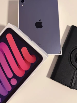 iPad Mini 6gth 64Gb WI-Fi - Säljer en lila iPad Mini 6 från Apple. Surfplattan har en stilren design i aluminium och kommer med originalkartong samt ett svart fodral i konstläder. Perfekt för surf, appar och underhållning. Laddare och tillbehör kan ingå beroende på överenskommelse.