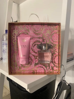 Versace Bright Crystal  - Lyxig presentbox från Versace med parfymen Bright Crystal och tillhörande body lotion. Båda produkterna kommer i snygga rosa förpackningar med guldiga detaljer. Parfymen är provad samt body lotion båda är nästan helt fulla, lotionen är använd en gång på hand sen inget mer. Köpt för 899kr.