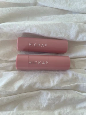 Hickap Sandy Glow Highlighter Stick - Krämig highlighter och rouge i stickformat från Hickap i nyansen Sandy Glow och peachy vibe . Kommer i en snygg, ljusrosa hylsa med vit text. Perfekt för att ge ansiktet en fräsch och naturlig lyster. Innehåller 7 g. Endast testade, 100kr får båda