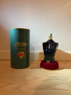 Jean Paul Gaultier Le Beau Parfum 125ml - Jean Paul Gaultier Le Beau Parfum i en snygg, mörkgrön flaska. Kommer med originalförpackning i metall och röd sammetsbas. En ikonisk och lyxig parfym som sticker ut i hyllan.