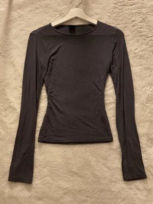  långärmad topp - En stilren svart långärmad topp med rund halsringning och figurnära passform. 