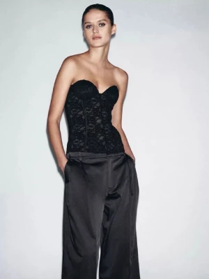 Svart spetskorsett topp från Zara - Säljer en svart korsett med bygel och vacker spetsdetalj. Toppen är axelbandslös och har en figurnära passform som framhäver siluetten. Perfekt för att skapa en edgy och trendig look. Från Zara och helt oanvänd med prislappen kvar! 