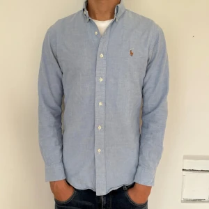 Ralph Lauren skjorta  - Riktigt fin Ralph Lauren skjorta i färgen ljusblå. Storlek S och modellen på bilden är cirka 180 cm. Slim fit Oxford. Nypris cirka 1799 kr. 
