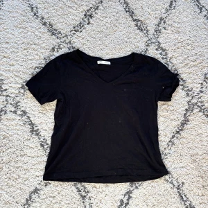 Svart t-shirt - Svart t-shirt med en liten v-ringning, superskönt material!!