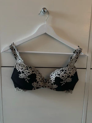 Intimissimi bh - Snygg svart bh med beige spetsdetaljer och blommigt mönster från Intimissimi. Bh:n har vadderade kupor och breda axelband med spets. Bh:n är endast provad, aldrig använd då den inte passar💕modellen Superpushup behå Giola Pretty Flowers