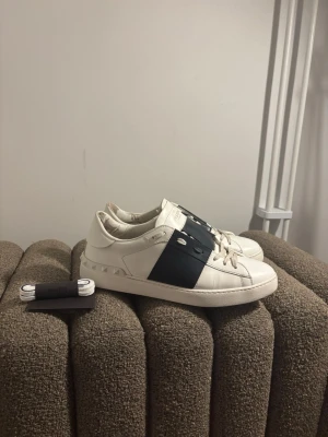 Valentino Open mörkblå - Säljer mina skitsnygga valentino open sneakers i vit med ränderna i färgen mörblå. Stl 44. Otroligt bra skick förutom deffekterna i  hälarna på insidan *vänligen se sista bild. Utöver de otroligt välhållna. 