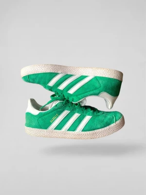 Adidas Gazelle gröna / EU 38 - Gröna Adidas Gazelle sneakers i mocka med klassiska vita ränder på sidorna och vit häl. Skorna har lågt skaft, platt sula och snörning framtill. Perfekta för en sportig och retro look. 