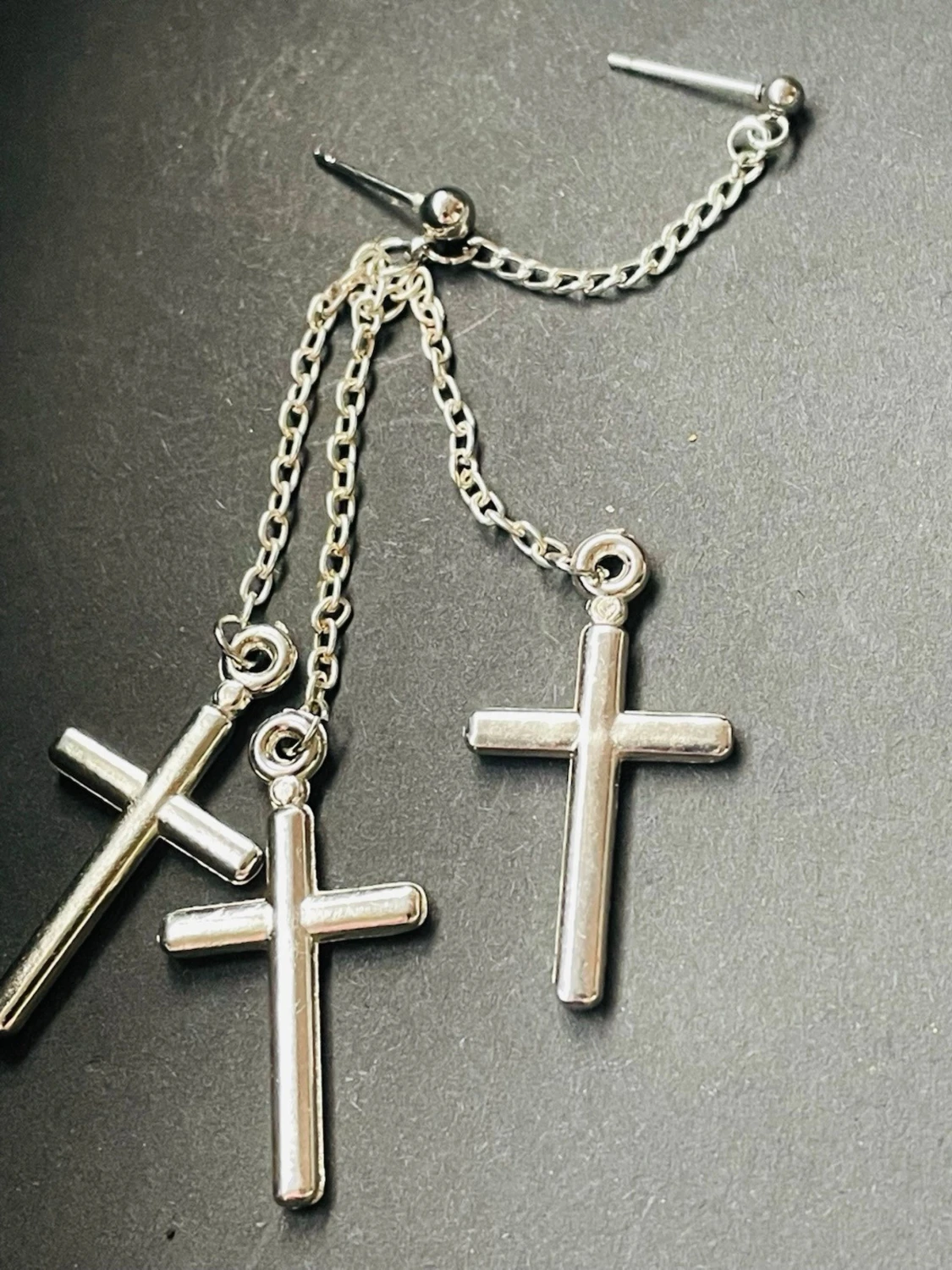 1 st trendigt silvrigt örhänge med tre korshängen på tunna kedjor. Örhänget har en cool och edgy look med blank finish och passar perfekt för dig som gillar statement-smycken. Lätt vikt