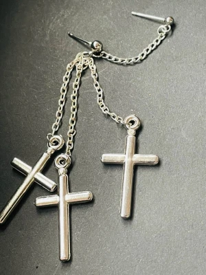 1 st trendigt silvrigt örhänge med tre korshängen på tunna kedjor. Örhänget har en cool och edgy look med blank finish och passar perfekt för dig som gillar statement-smycken. Lätt vikt  - 1 st trendigt silvrigt örhänge med tre korshängen på tunna kedjor. Örhänget har en cool och edgy look med blank finish och passar perfekt för dig som gillar statement-smycken. Lätt vikt 
