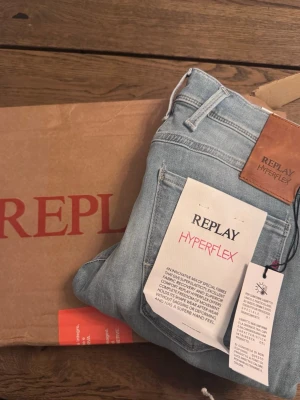 Replay Hyperflex ljusblå jeans - Säljer ett par snygga ljusblå jeans från Replay Hyperflex med klassisk femficksdesign och skinnpatch bak i midjan. Jeansen har en modern passform och är tillverkade i ett stretchigt material som ger extra rörelsefrihet. Helt nya!!!, nypris 1699, Köpa på replays egna hemsida!!
