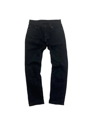 Svarta Levi's 511 jeans - Svarta jeans från Levi's modell 511 med klassisk femficksdesign och smal passform. Jeansen har en snygg svart tvätt, Levi's patch och röd etikett bak. Perfekta för dig som gillar en clean och stilren look. Materialet är slitstarkt jeans.