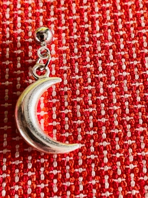 By prisförslag- 1 st Silvrigt örhänge med måne - Coolt örhänge i silverfärgad metall med hängande måne. Månen har en snygg böjd form och örhänget fästs med en liten rund plupp. Perfekt för dig som gillar unika detaljer och vill sticka ut med din stil.