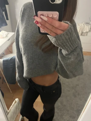 Grå stickad tröja från Zara - Säljer en grå stickad tröja från Zara! Den ör ribbad längst upp vid halsen, vid ärmarna och längst ner på tröjan. Jätte mysig och varm🥰 Perfekt för kalla vinter dagar💗