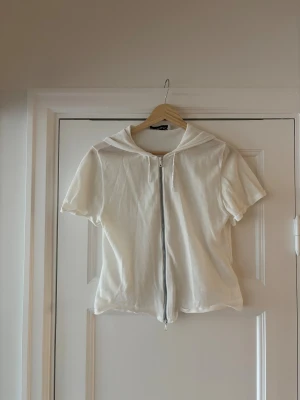 Topp från Our Legacy - Kort topp med luva från Our Legacy. Dragkedja som går åt två håll (se bild) väldigt skönt och tunt tyg. Mycket fin :) storlek 42 men passar 38-42 