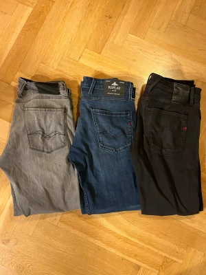 Replay jeans-paket i grått, blått och svart W31 - Tre par snygga Replay jeans säljes! Ett par grå, ett par klassiskt blå och ett par svarta. Alla har raka ben och femficksdesign med Replay-logga på bakfickan. Materialet är mjukt jeans och passformen är slim. Alla har W31. Säljer alla för tillsammans 699kr  men om du är intresserad av att köpa ett av dom går de också för 299kr