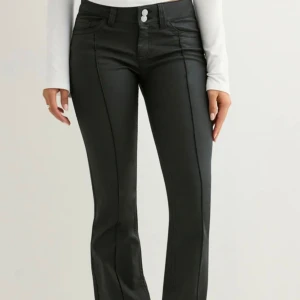 Oanvända!! svarta bootcut byxor från Nelly - Snygga svarta byxor från Nelly med bootcut-modell och markerade sömmar längs benen. Byxorna har används en gång. Säljer dom för jag köpte i fel storlek