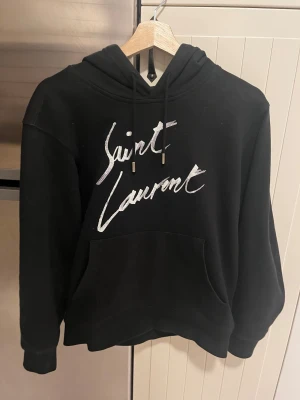 Saint Laurent hoodie - Säljer nu denna Saint laurent hoodien i modellen ”Signature hoodie” i storlek S✨ är i bra skick och har inga defekter.
