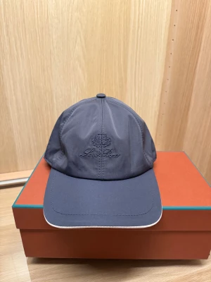 Loro Piana Keps  -  Säljer denna Loro Piana keps i blå i nyskick. Aldrig använd, lyxig och stilren modell som passar alla outfits. ✨