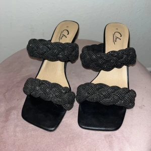 Svarta klackskor med glitter - Snygga svarta klackskor från clou. Klackarna är endast använda en gång på balen! Så dom är så gott som nya!  Storlek 38 och sann i storleken.