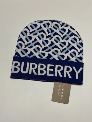 Burberry Mössa - Säljer en helt ny mössa, aldrig använd. Storlek One size. Snabb frakt fraktas inom 24h efter köp. Kan härmas i Haninge, skriv gärna vid fler frågor.