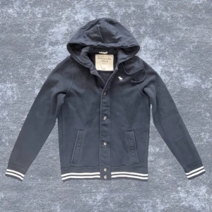 Marinblå hoodiejacka Abercrombie - Fet marinblå hoodiejacka från Abercrombie. Skönt plagg till nuvarande säsong. Asfet luva i dun. Passar dig mellan 183-190 cm. Hör av dig vid frågor :) Priset kan diskuteras