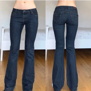 Mörkblå bootcut jeans  - Snygga mörkblå jeans med klassisk femficksdesign och bootcut-ben. Jeansen har låg midja och midjemåttet rakt över är ca 40 cm. Innerbenslängden är ca 82 cm. De är Skriv gärna vid frågor!!