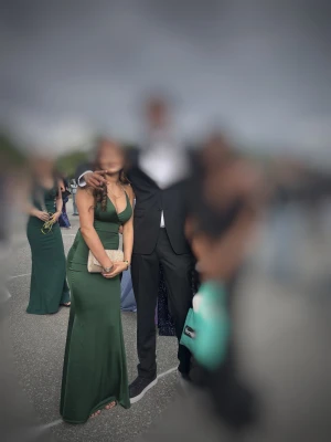 Mörkgrön balklänning med glittriga band rygglös! - Snygg mörkgrön långklänning med figurnära passform och v-ringad front. Klänningen har smala axelband och öppen rygg med glitter band som ger en extra snygg detalj . Materialet är mjukt och har ett lätt glansigt utseende, perfekt för bal,fest eller bröllop. Finns ej i Sverige och köpt för 2500, och säljer för 999kr.Pris kan diskuteras!☺️