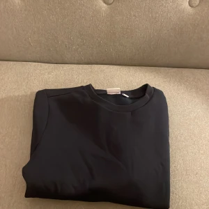 Svart sweatshirt från Andy by Frank Dandy - Blå sweatshirt från Andy by Frank Dandy i storlek S. Tröjan har rund hals, långa ärmar och en enkel, clean look utan mönster eller detaljer. Perfekt för chill dagar och enkel att matcha med jeans eller joggers. Priset inte huggit i sten🤗🤗