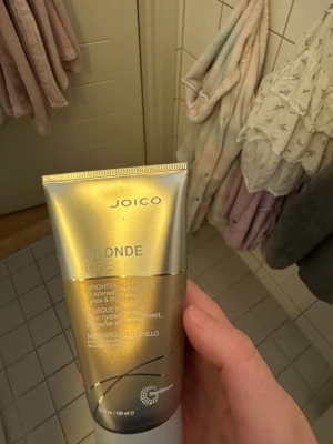 Joico Blonde Life Brightening Masque - Joico Blonde Life Brightening Masque i en snygg guld- och silverfärgad tub på 150 ml. Perfekt för dig som vill ge ditt blonda hår extra lyster och intensiv återfuktning. Tuben har en modern design och är enkel att använda.