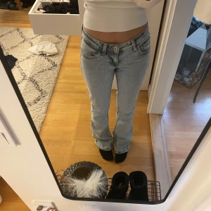 Ljusblå bootcut jeans - Säljer ett par ljusblå bootcut jeans med låg midja. De har en klassisk femficksdesign och en snygg tvätt som ger en avslappnad look. Perfekta för en casual stil. Midjemått - 32 & innerbenslängd - 80